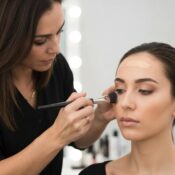 Women applying makeup in a bright bathroom, demonstrating oily-skin aftercare techniques