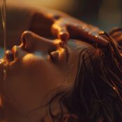 specialist's hands working through a client's hair with focused, deliberate pressure during a head spa session. Soft, warm lighting. Peaceful, elevated studio setting.