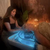 Woman giving a scalp massage to a client in a serene spa setting.