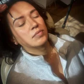 Woman receiving eyebrow treatment while relaxing in a beauty salon.